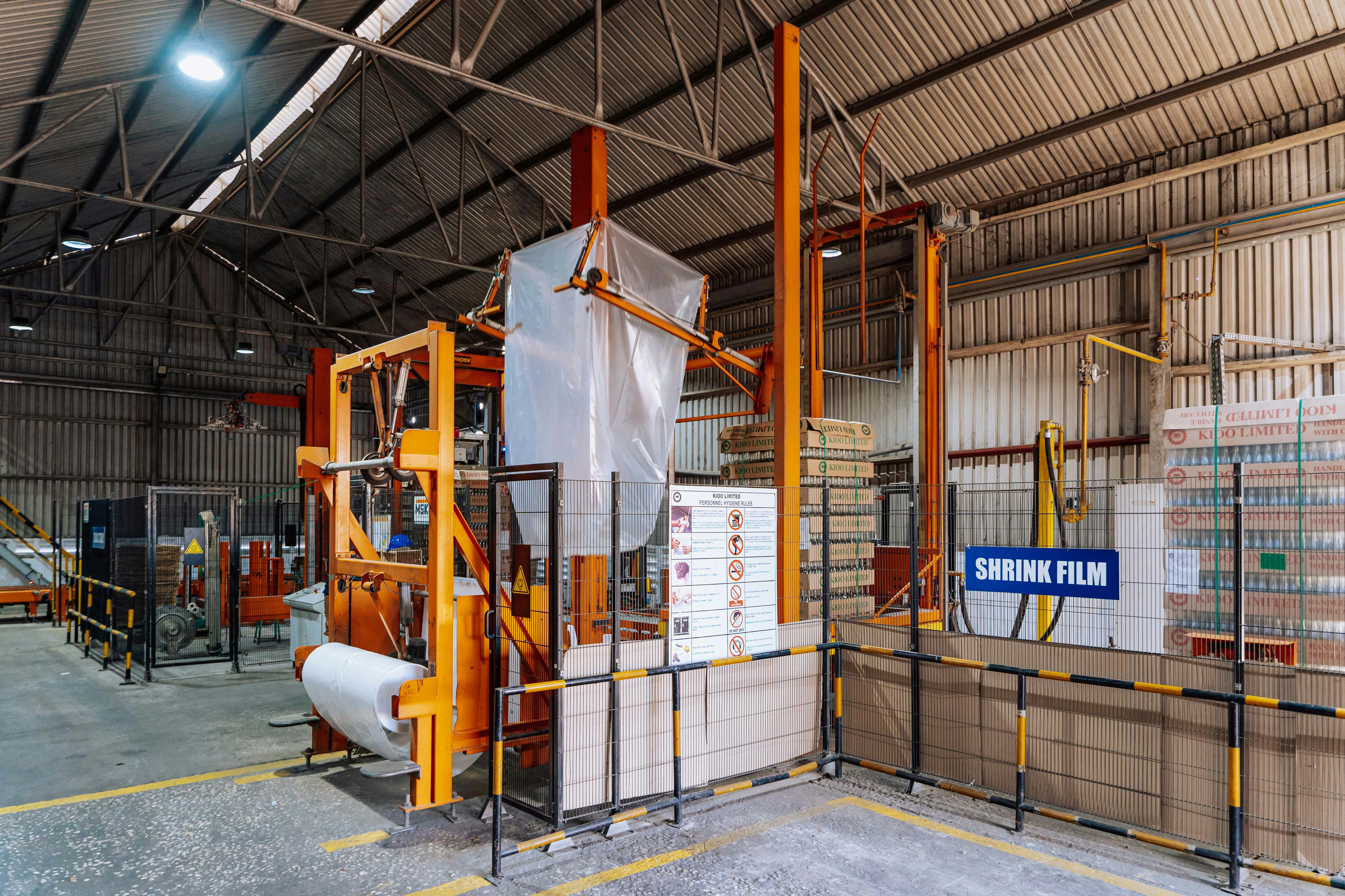 Interior view of a warehouse in Dar es Salaam with a shrink film machine and industrial equipment. — Industry 4.0 and sm...
