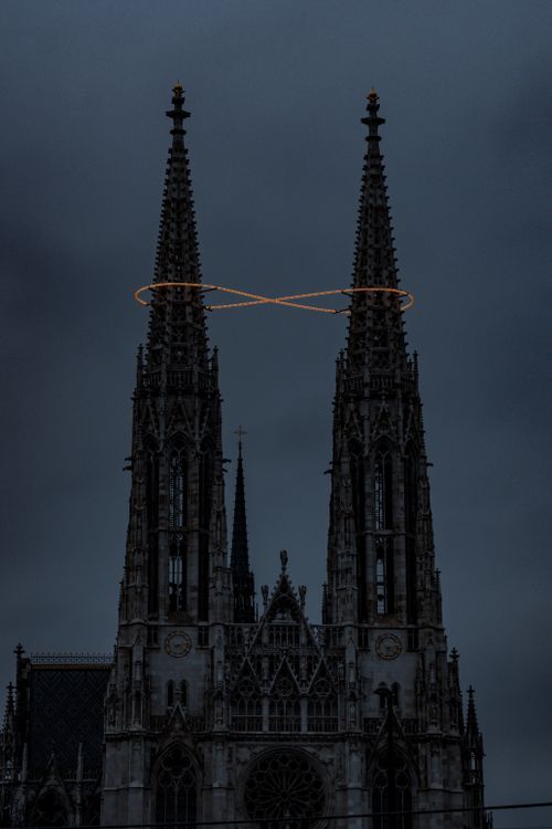 Free Dramatic view of Vienna's Votivkirche spires with halo lighting at dusk. Captivating Gothic architecture. Stock Photo