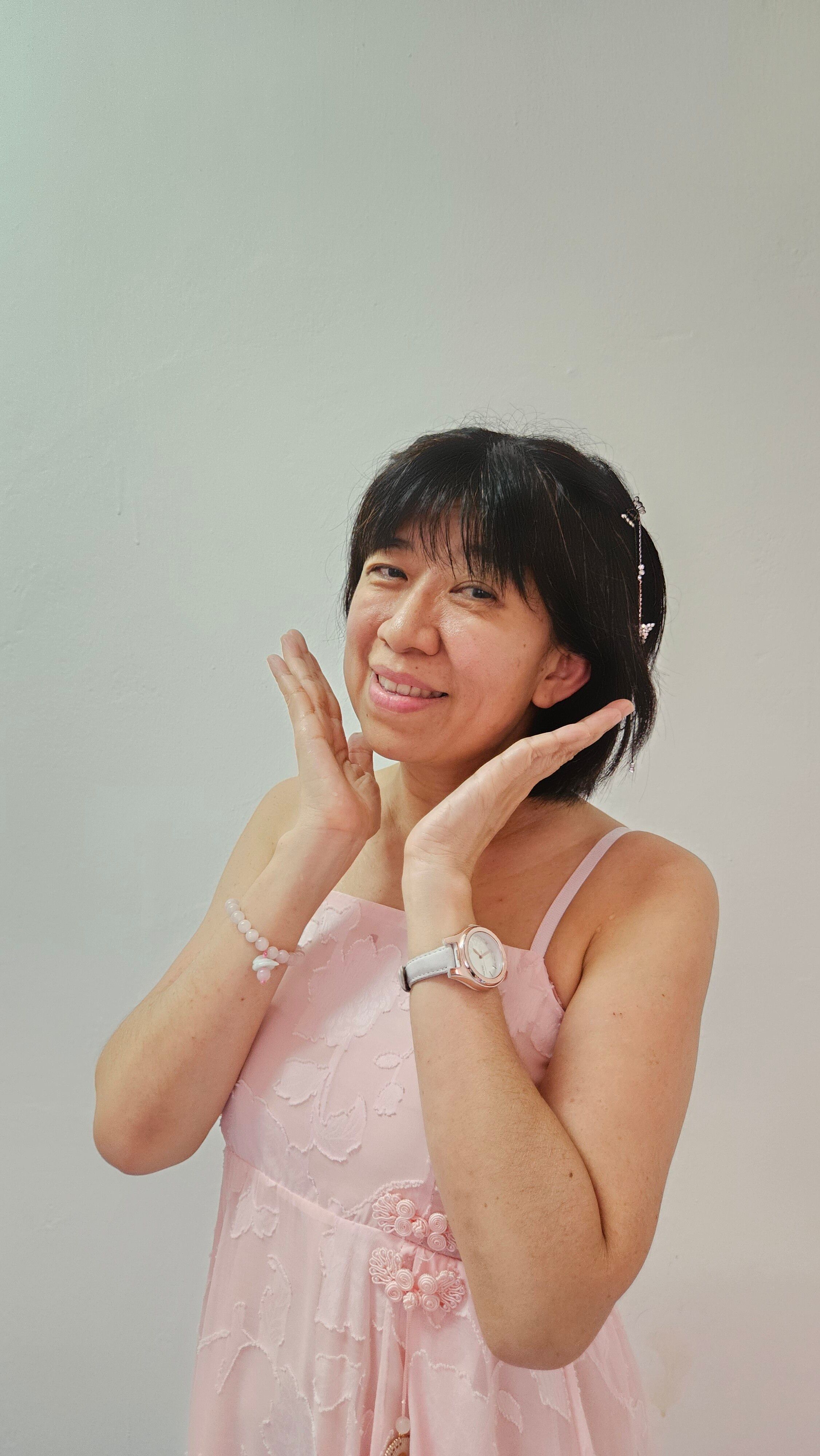Smiling woman in a pink dress, posing with joy indoors. Perfect for lifestyle and fashion content.