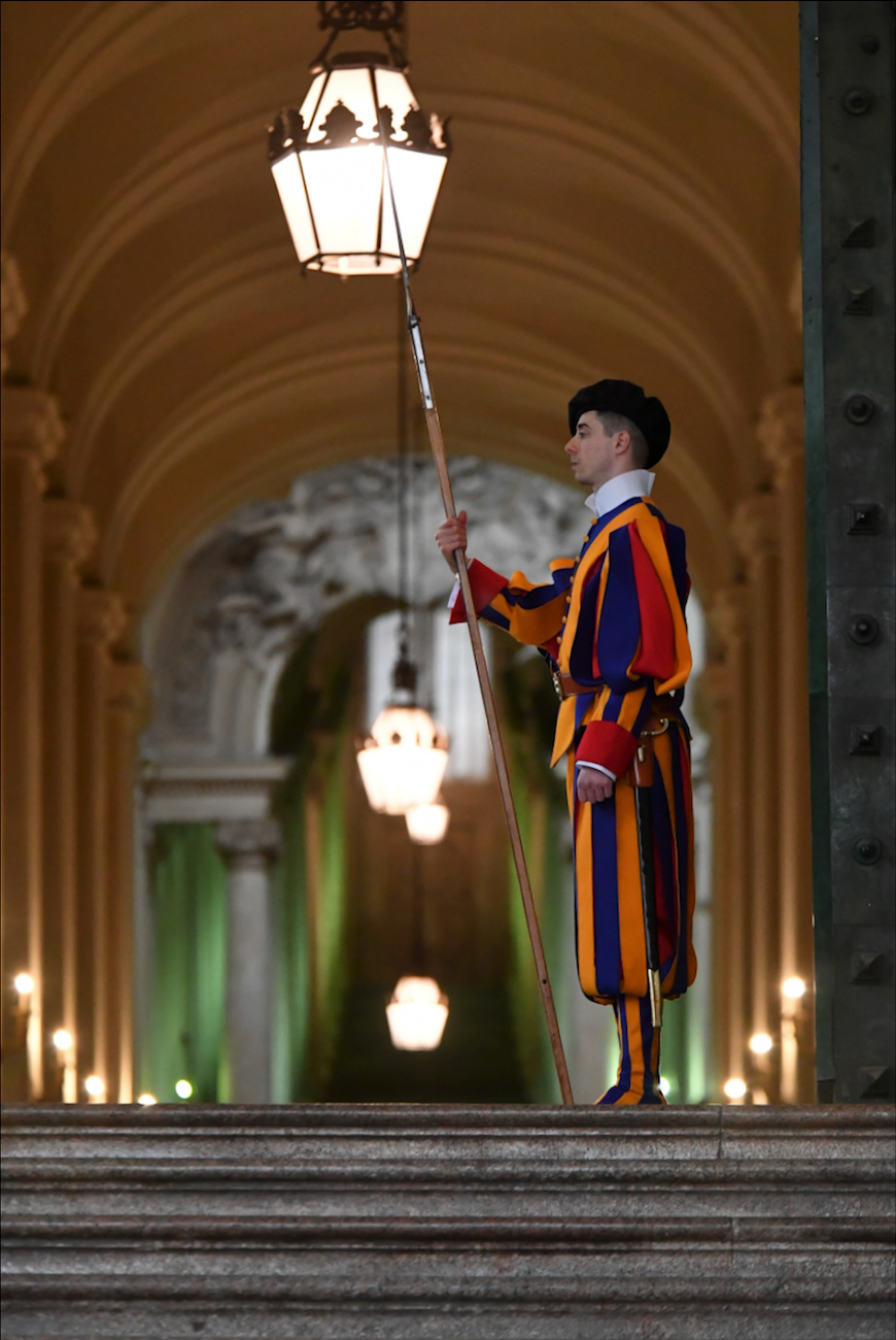 Swiss Guard standing in traditional uniform at Vatican. Iconic shot of ceremonial Swiss Papal Guard known for their colorful attire.