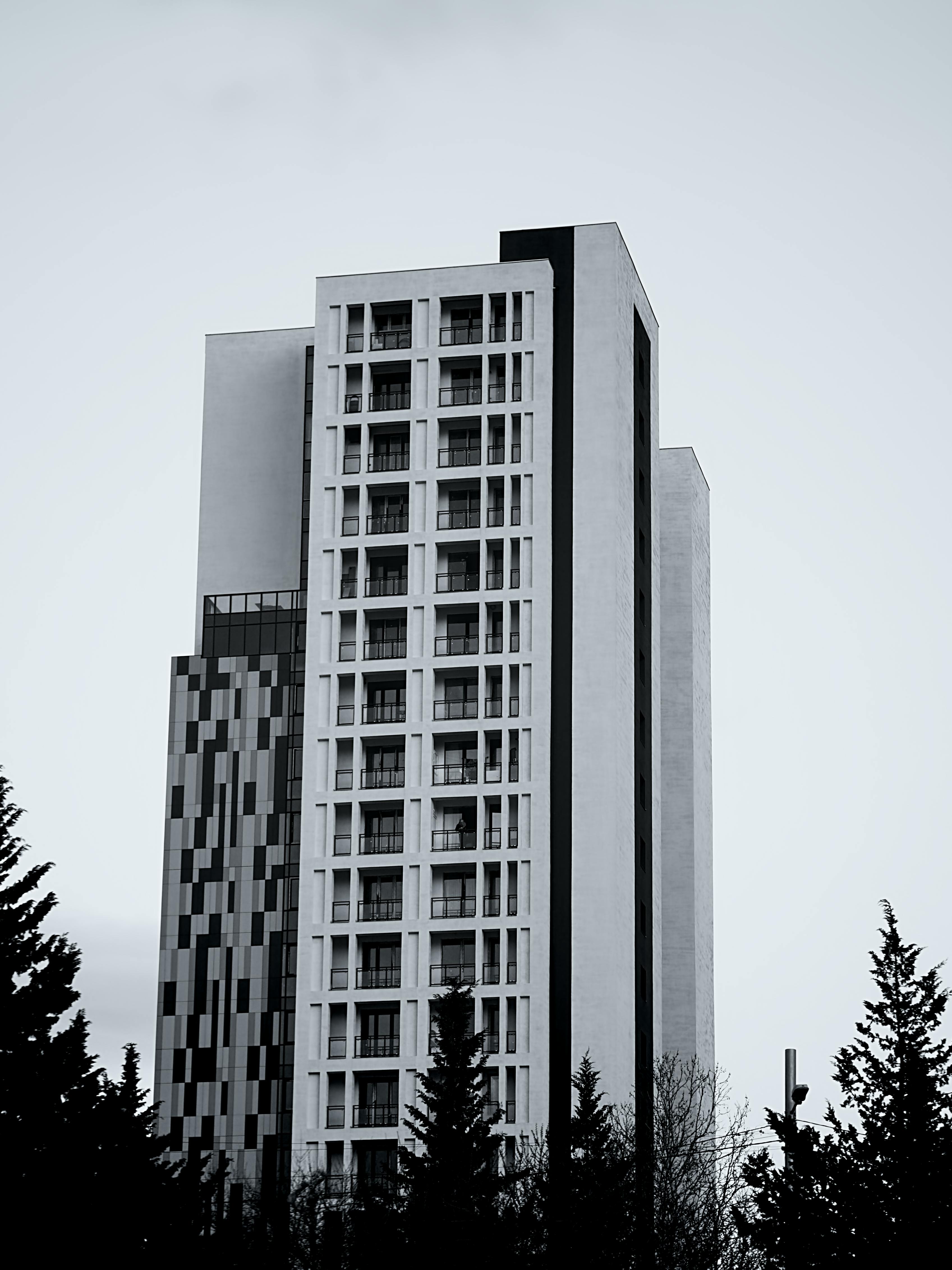 De franc Vista monocroma d'un edifici modern de gran alçada amb disseny geomètric contra un cel clar. Foto d'estoc