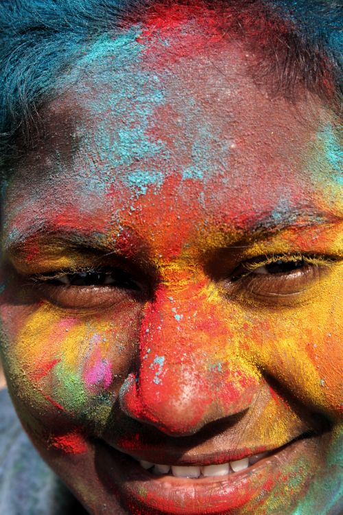 Free Close-up of a joyful face covered in colorful Holi powders during the vibrant festival in India. Stock Photo