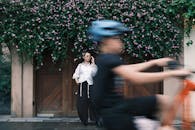 Woman on Phone with Cyclist Blurred in Foreground