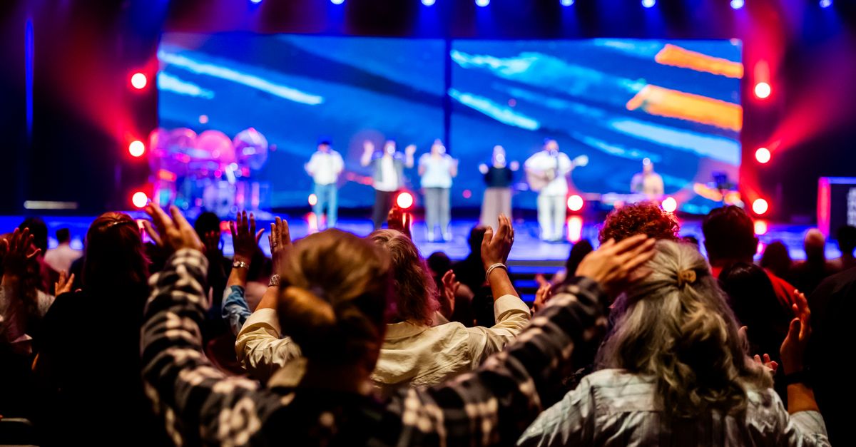 Young musicians performing on stage at a Christ Embassy youth event with vibrant lighting and engaged audience