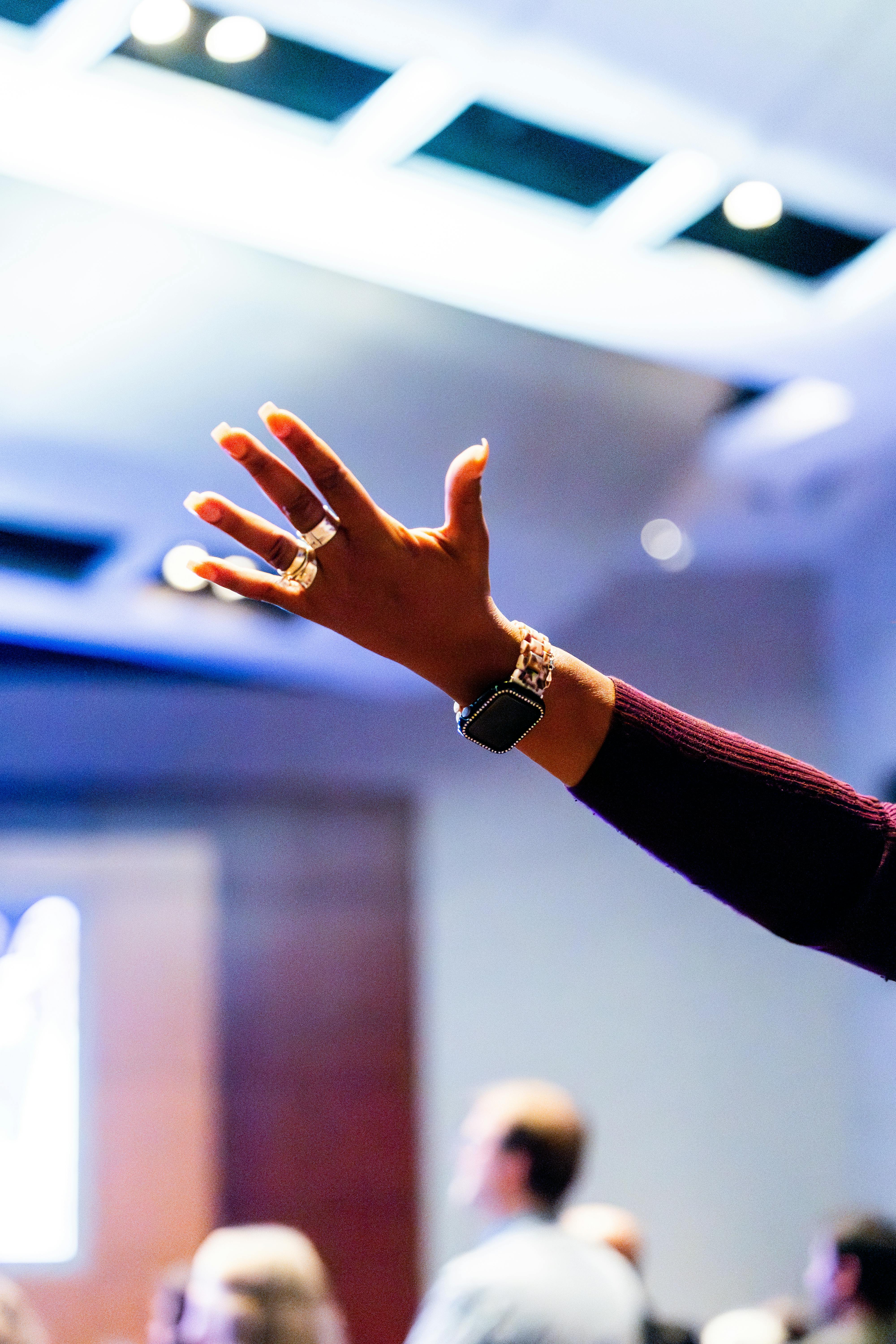 A person raising their hand at a conference, showcasing active engagement.
