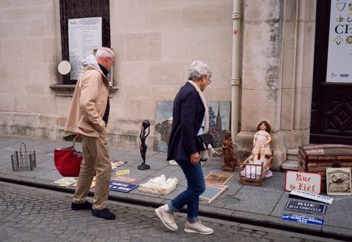 Free An elderly couple browses a vintage street market in Nancy, France. Historic charm and curiosity come alive. Stock Photo
