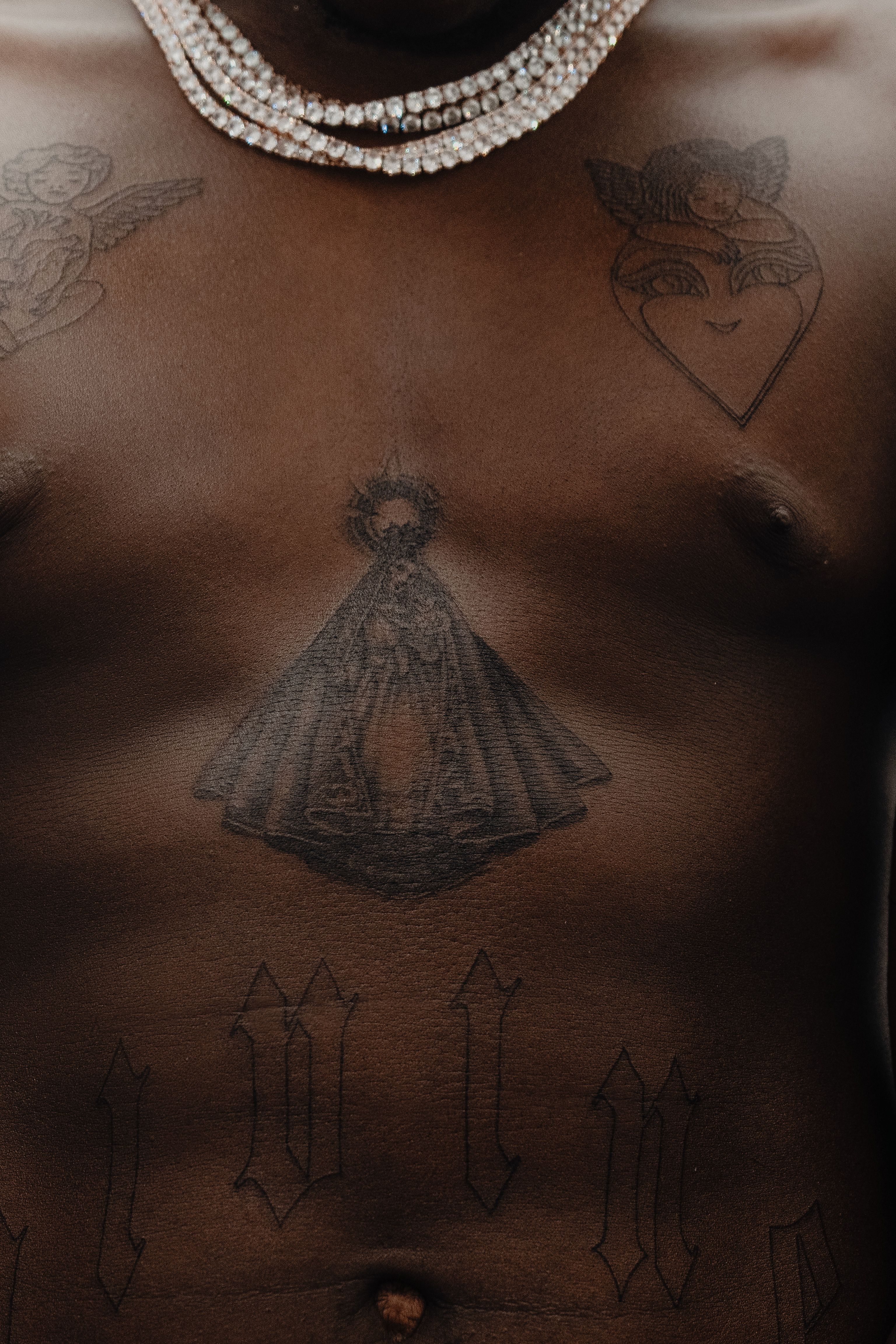 Artistic depiction of a tattooed male torso adorned with a diamond necklace.
