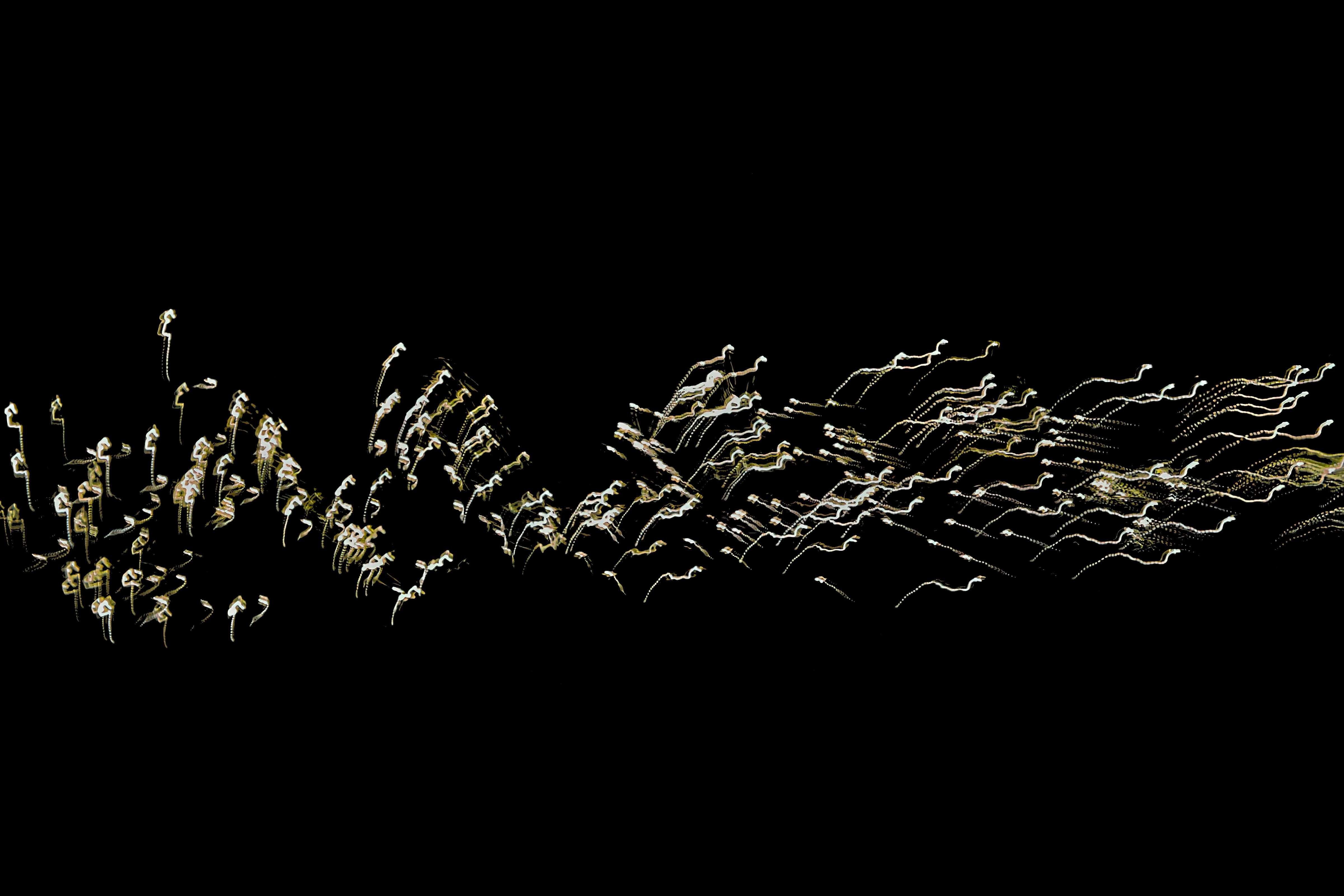 Free Abstract light trails creating dynamic patterns against a dark background. Stock Photo