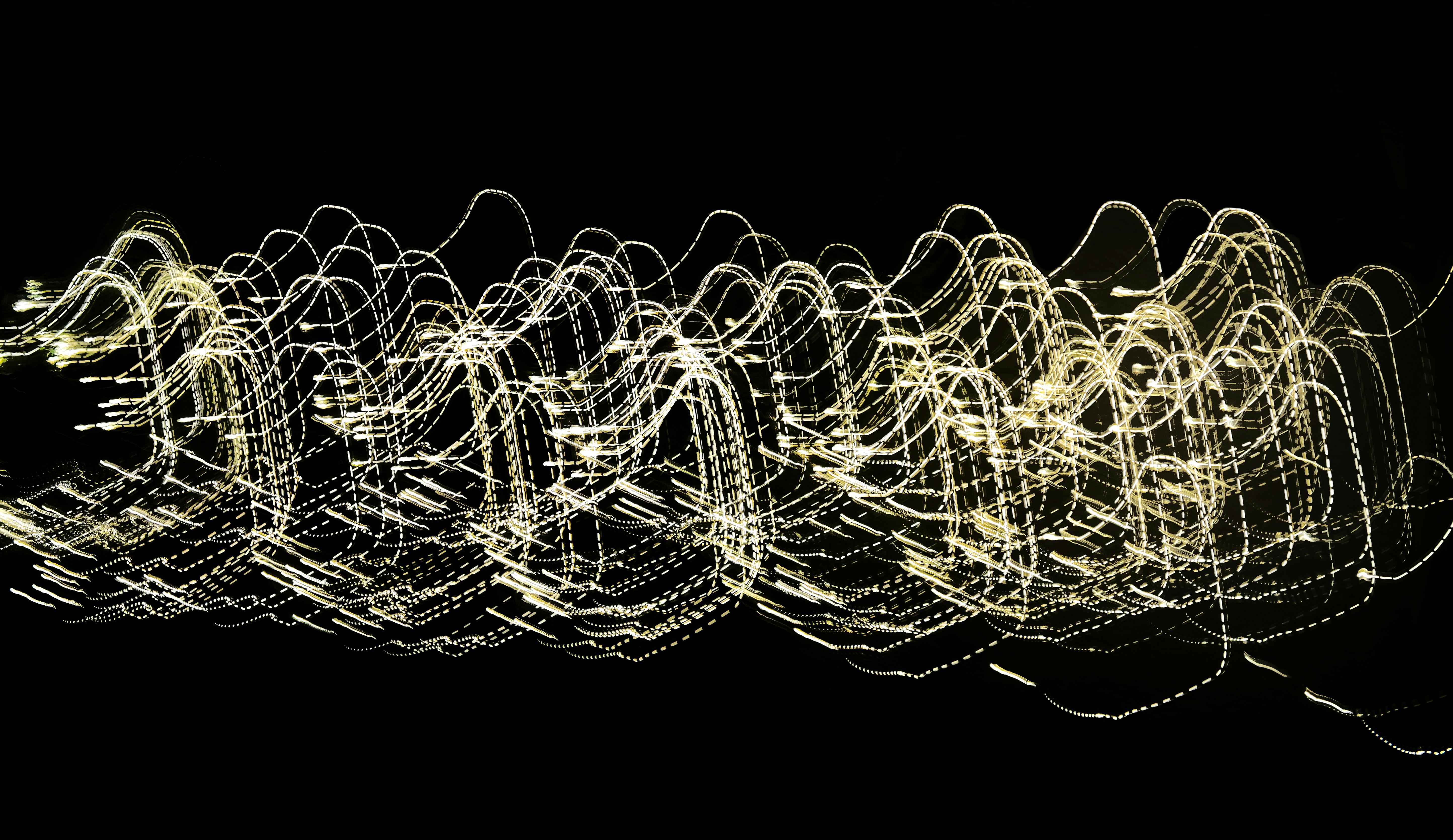 Gratis Imagen abstracta dinámica de estelas de luz que crean patrones ondulados sobre un fondo oscuro. Foto de stock