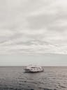 一艘孤独的游艇平静地漂浮在广阔多云的大海上
