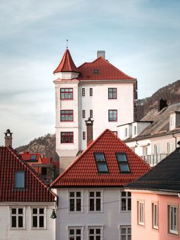 Charming European buildings with red roofs against a scenic mountain backdrop.