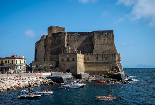 Free View of Castel dell'Ovo in Naples, featuring boats and the Mediterranean Sea on a sunny day. Stock Photo