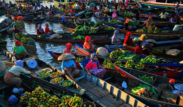 Colorful scene of a traditional floating market with fruit-laden boats.