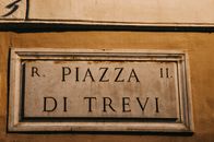 Close-up of Piazza di Trevi sign in Rome, showcasing historical architecture.
