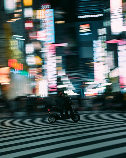 Free Dynamic shot of a motorcycle speeding across a crosswalk in vibrant nighttime Osaka. Stock Photo