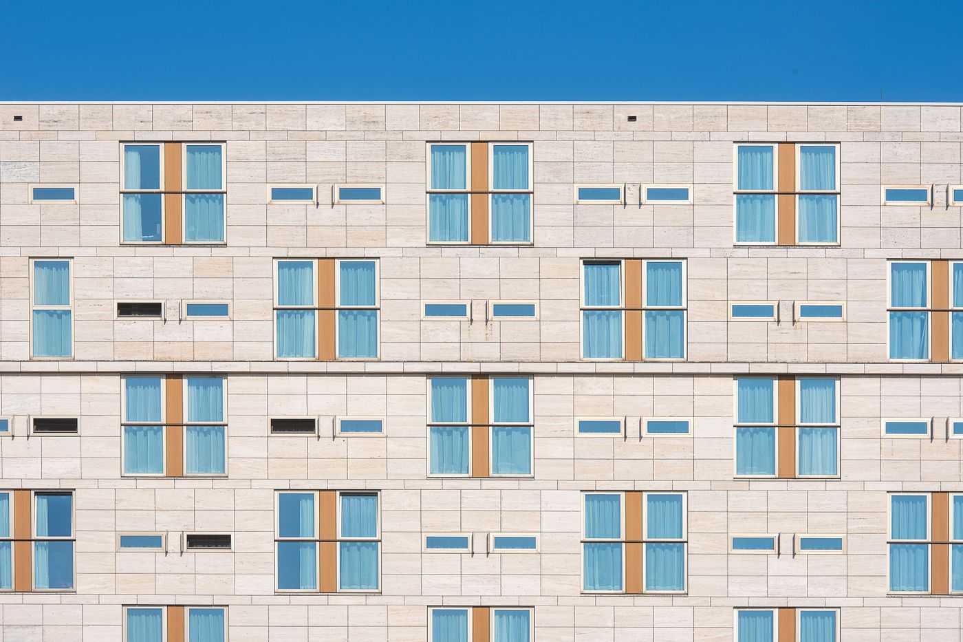 Stone facade of the hotel with its stacked window bays. Photo by Jan van der Wolf on Pexels.