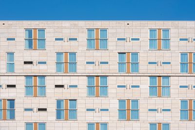 Minimalist hotel facade with symmetrical windows. Photo by Jan van der Wolf on Pexels