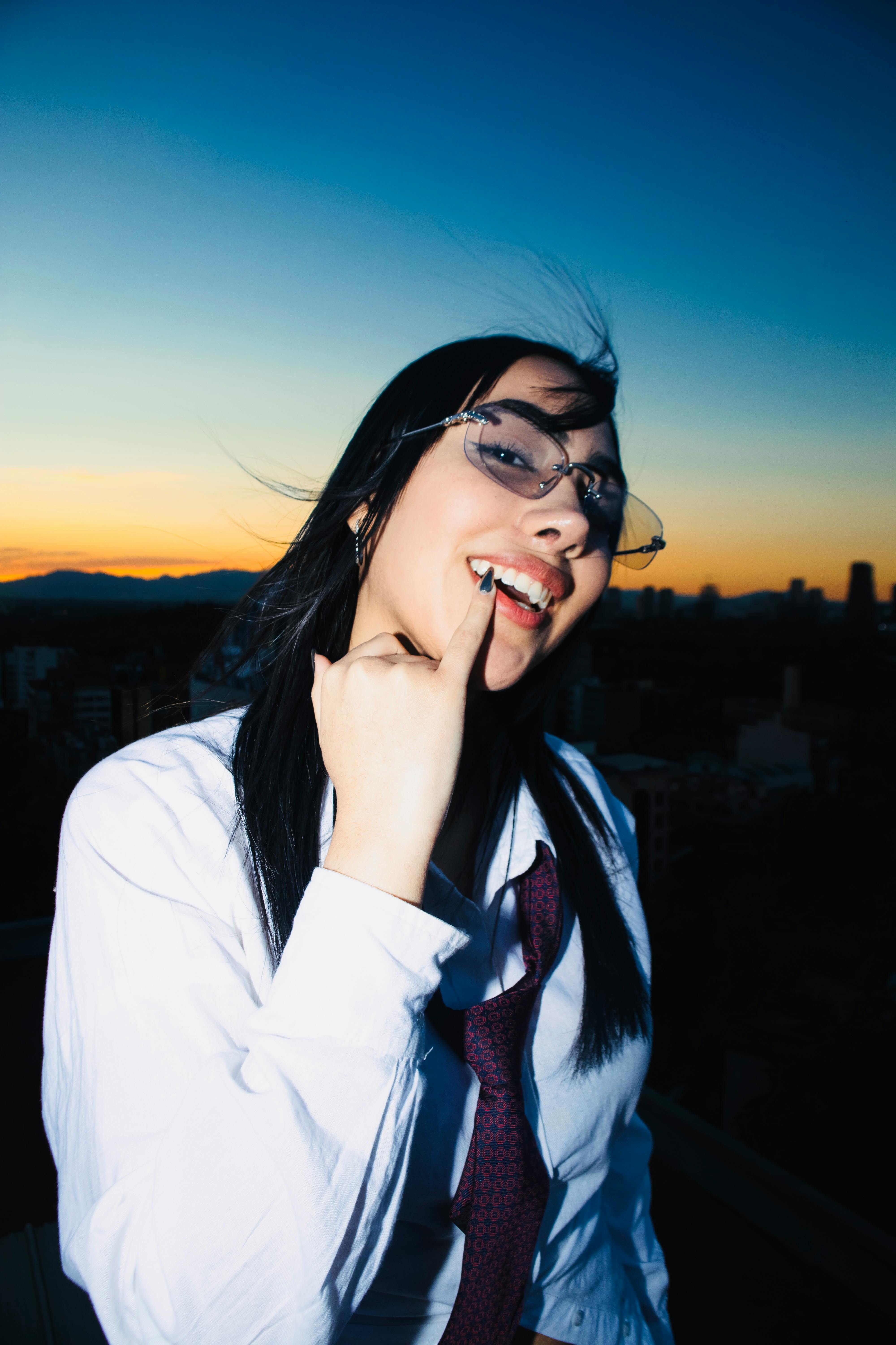 grátis Retrato vibrante de uma jovem de óculos posando ao pôr do sol na Cidade do México. Foto profissional