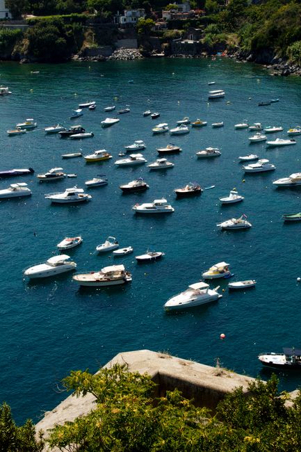A stunning aerial view of numerous boats floating in the clear blue waters off Ischia, Italy.