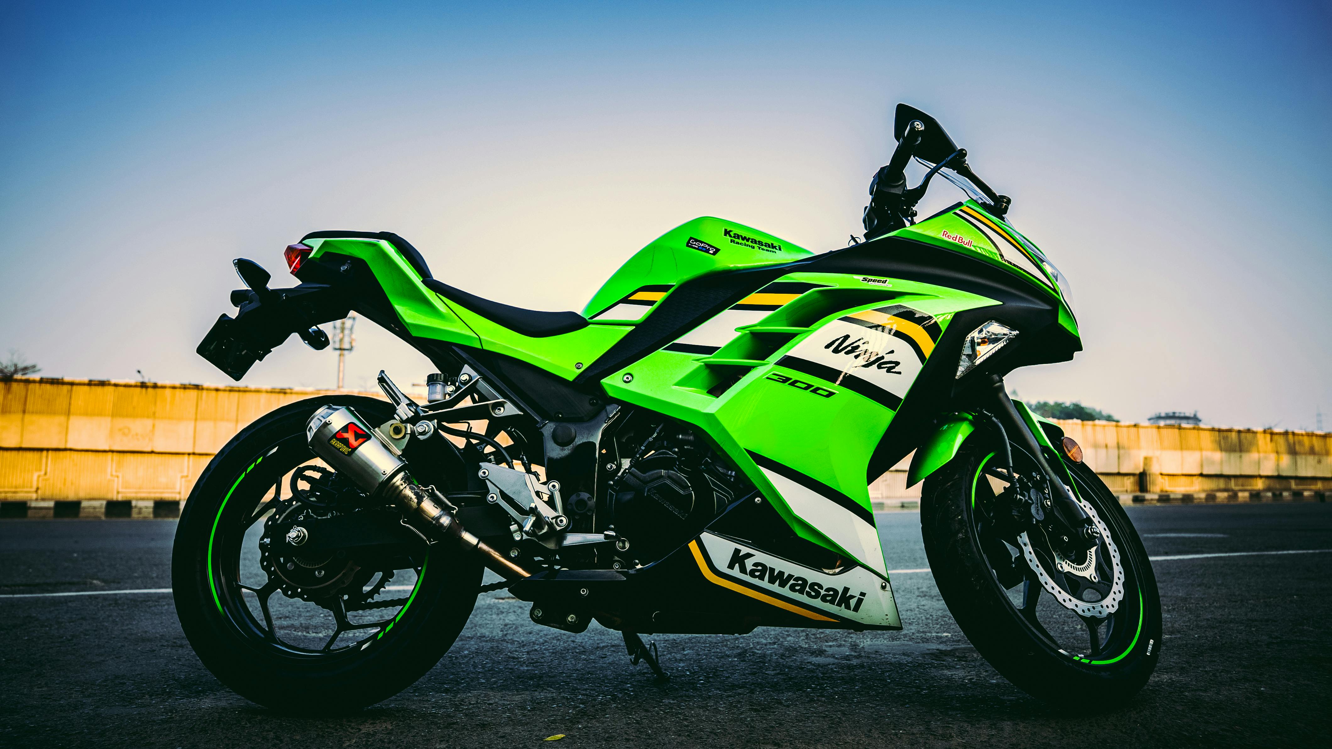 Vibrant green Kawasaki Ninja 300 motorcycle parked outdoors, showcasing its sleek design and powerful stance.