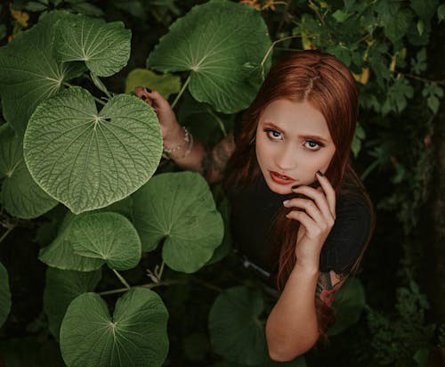 Woman with Red Hair Holding Green Leaves