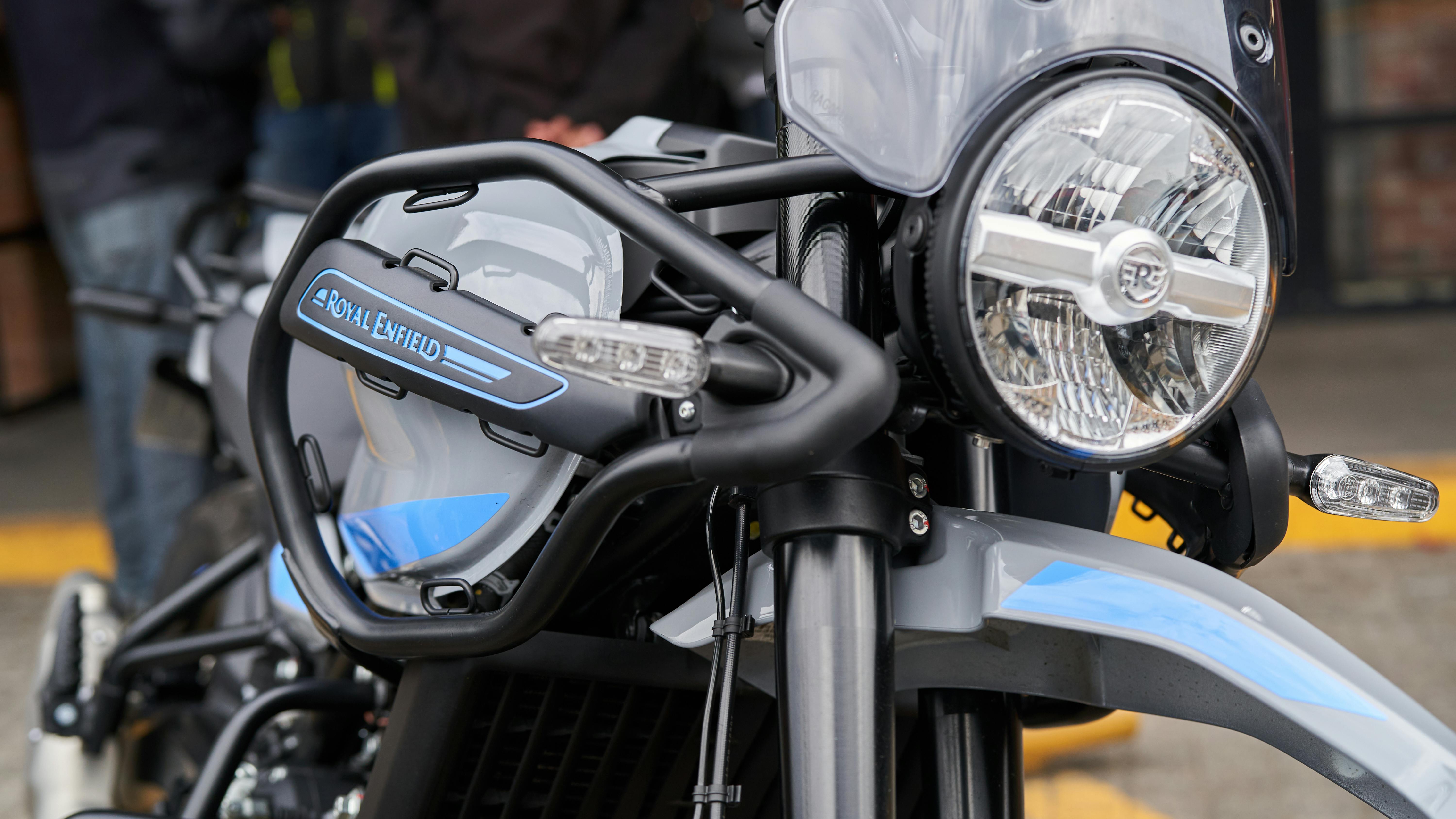 Detailed view of a Royal Enfield motorcycle headlight and design features taken outdoors.