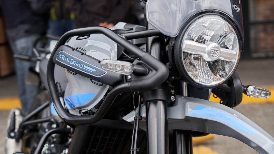 Detailed view of a Royal Enfield motorcycle headlight and design features taken outdoors.