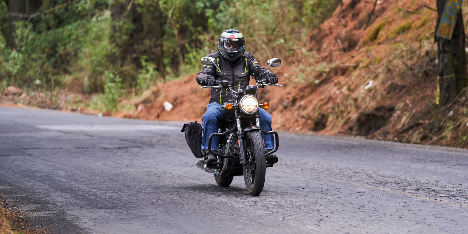 A biker riding a motorcycle on a winding countryside road