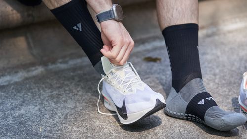 Free Close-up of a man tying his running shoe laces on a sunny day. Stock Photo