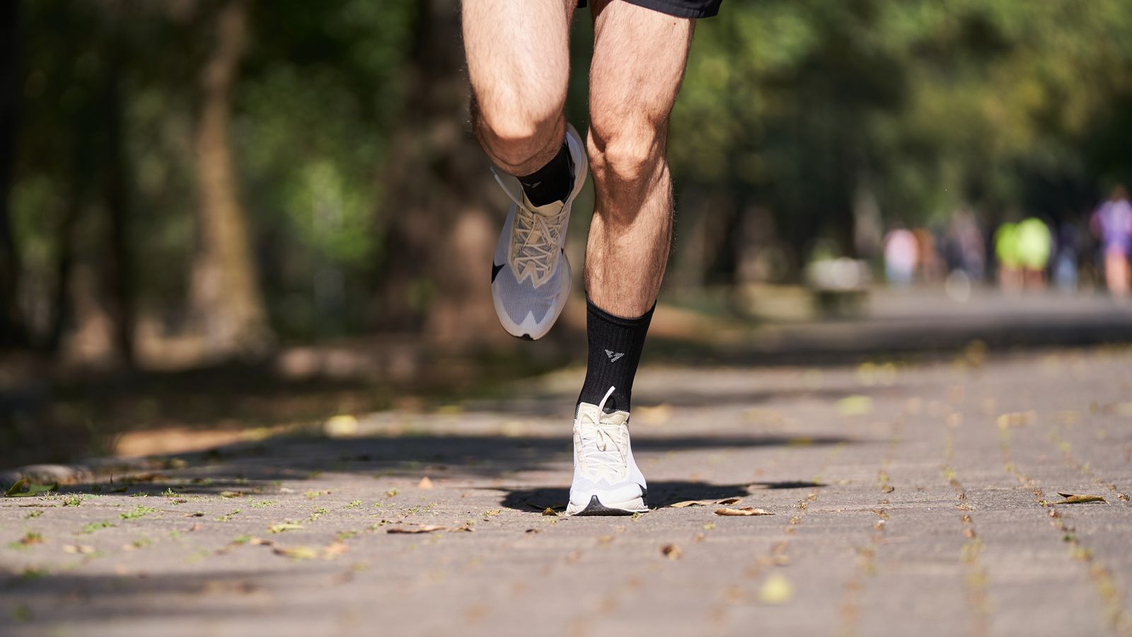 Runner stretching legs outdoors after training in bright daylight