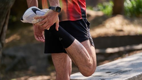 Free An athlete performs a stretching routine outdoors, highlighting fitness and healthy lifestyle. Stock Photo