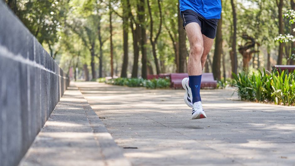 pexels photo 36429568 Man jogging on a tree-lined park pathway, creating a dynamic fitness scene.