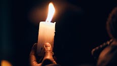 Hand Holding Candle in Dark Lighting Setting