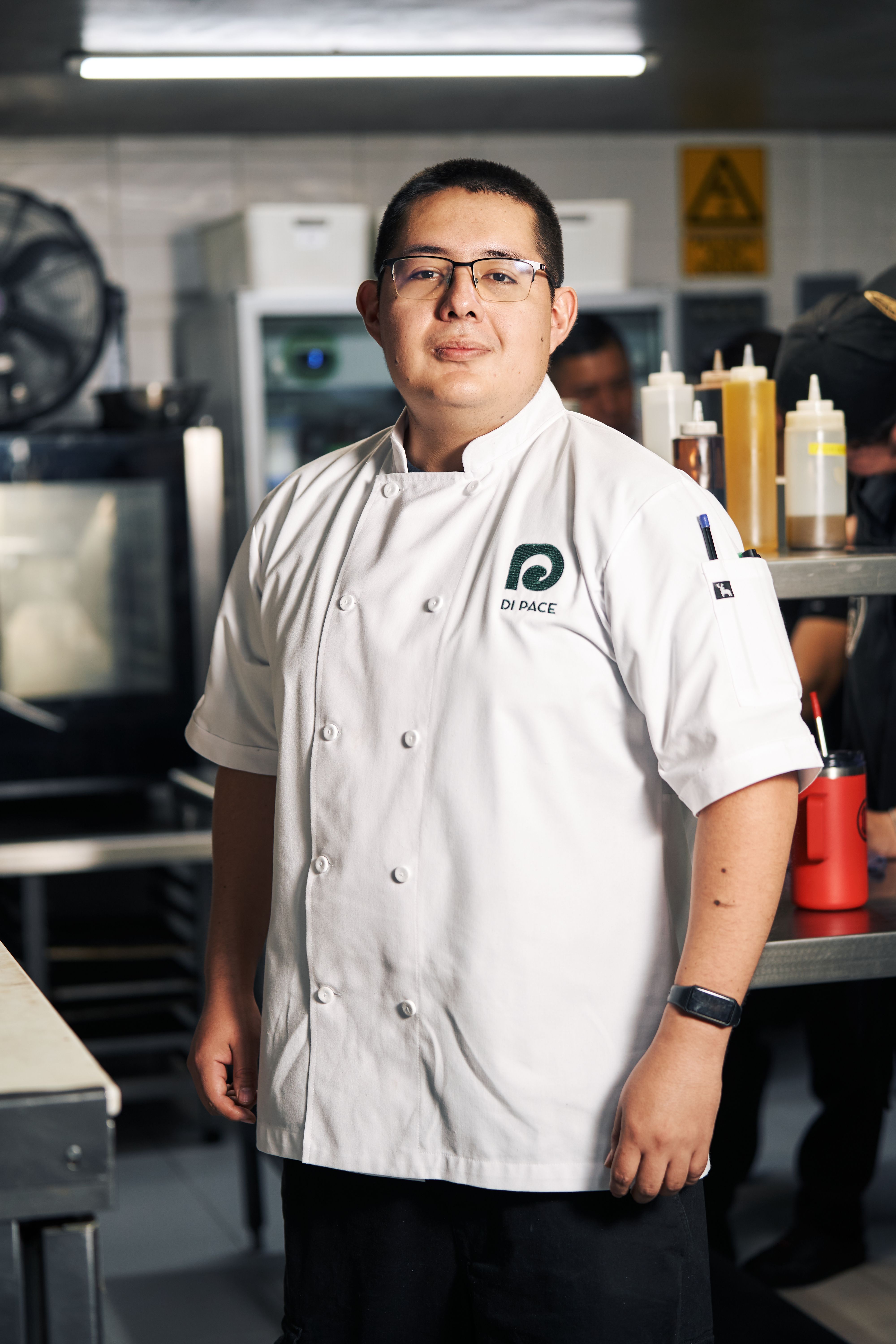 Founder in a restaurant kitchen holding a notebook