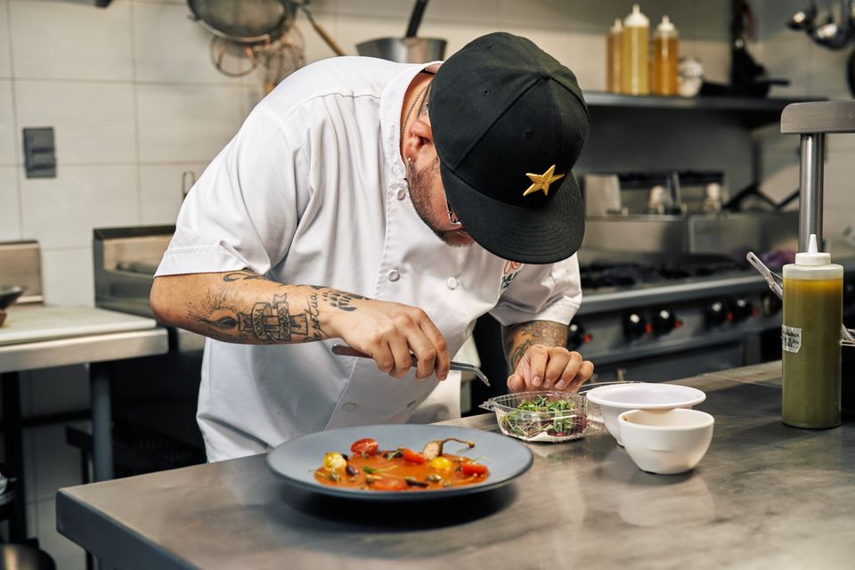Chef emplata un plato en la cocina profesional de un restaurante