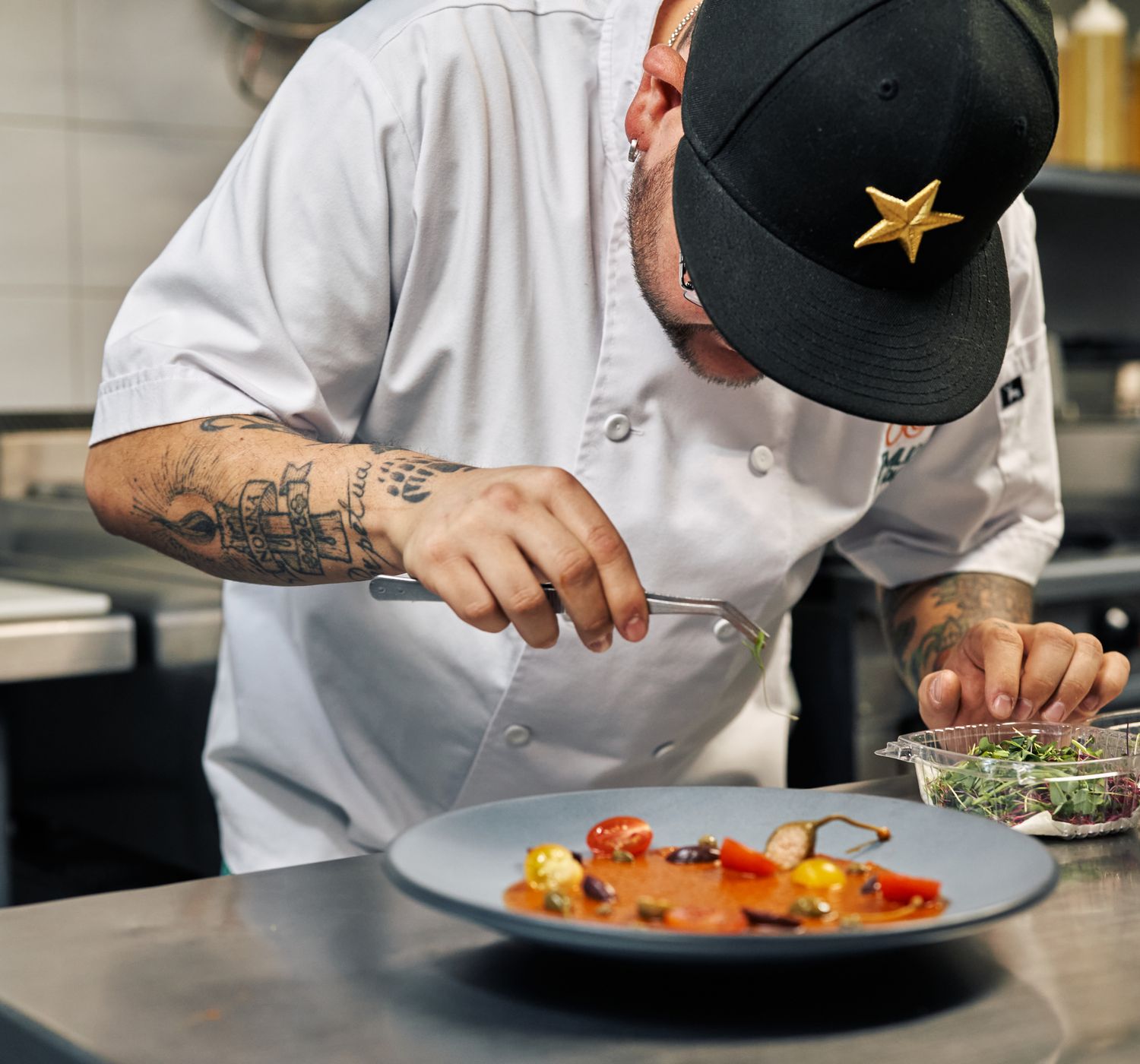 Chef finishing a plate over the open fire at Emberline
