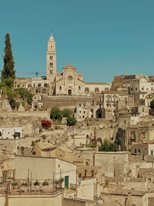 Free A breathtaking view of Matera's ancient stone buildings under a clear blue sky. Stock Photo
