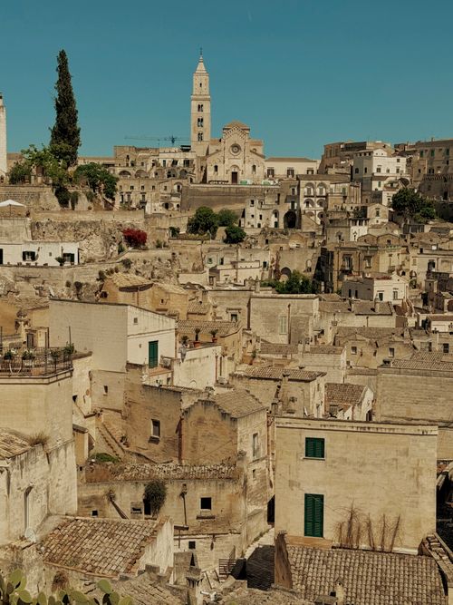 Free Explore the ancient beauty of Matera with its historic stone buildings and vibrant architecture under clear skies. Stock Photo