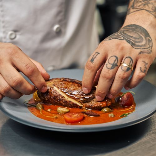 The chef's hands finishing a dish