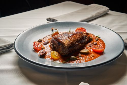 Free Juicy beef steak served with fresh cherry tomatoes and rich tomato sauce. Stock Photo