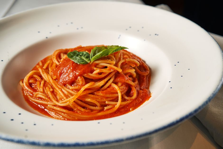 Spaghetti with red marinara sauce in a white bowl, minimalist plating`