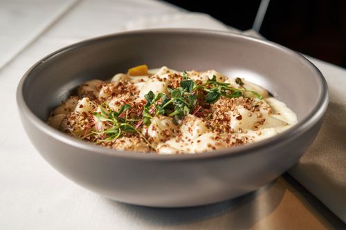Free A bowl of gnocchi pasta topped with cream sauce and fresh herbs. Stock Photo