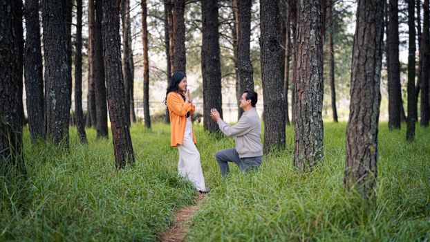 Heartfelt marriage proposal in a serene forest backdrop, capturing a romantic moment.