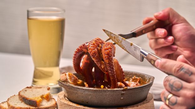 Fresh octopus tentacles being served with bread and beer, perfect for a gourmet dining experience.