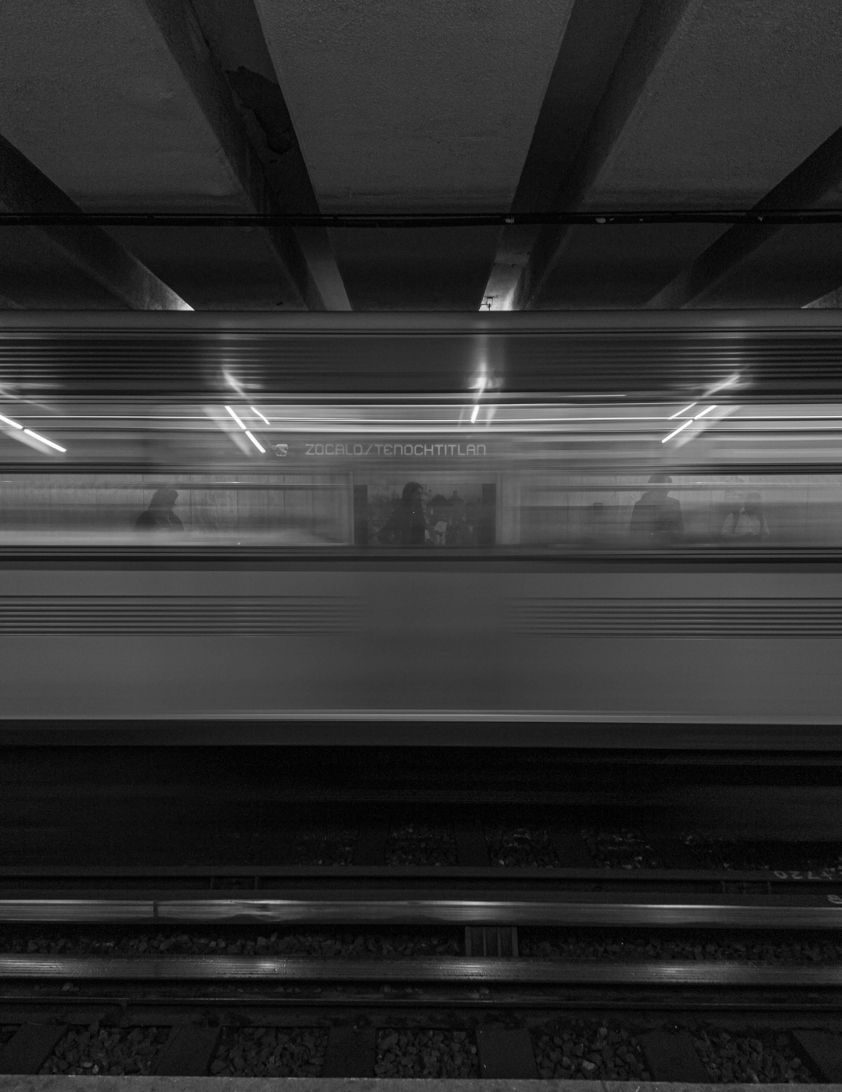 De franc Imatge borrosa d'un tren de metro que passa per una estació de metro en blanc i negre. Foto d'estoc