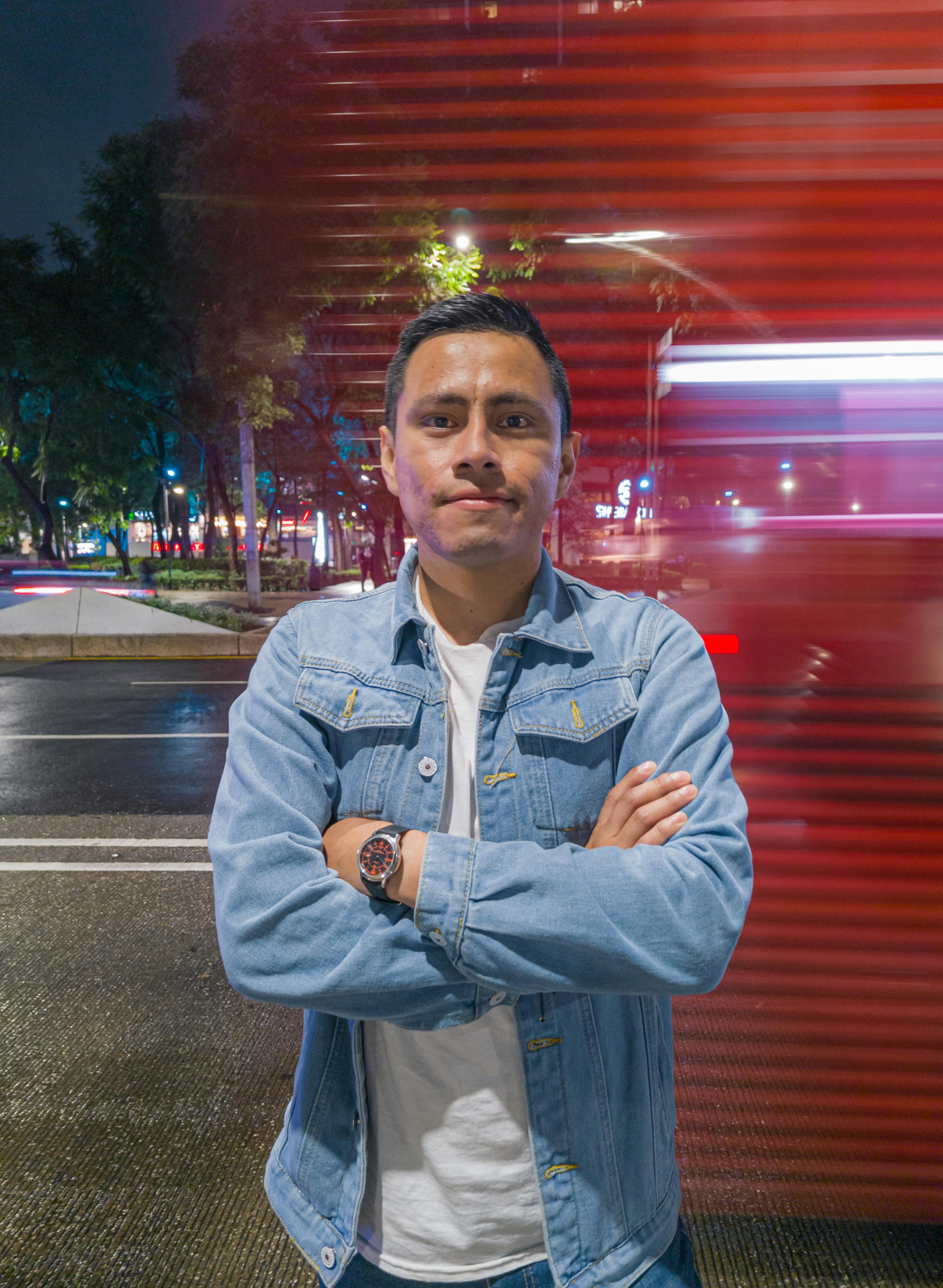 Gratis En mann står selvsikkert på en gate om natten i Mexico by, med uskarpe lys bak seg. Arkivbilde