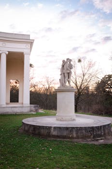 日落时分，优雅的古典雕塑坐落在宁静的莱德尼斯-瓦尔蒂斯景观中