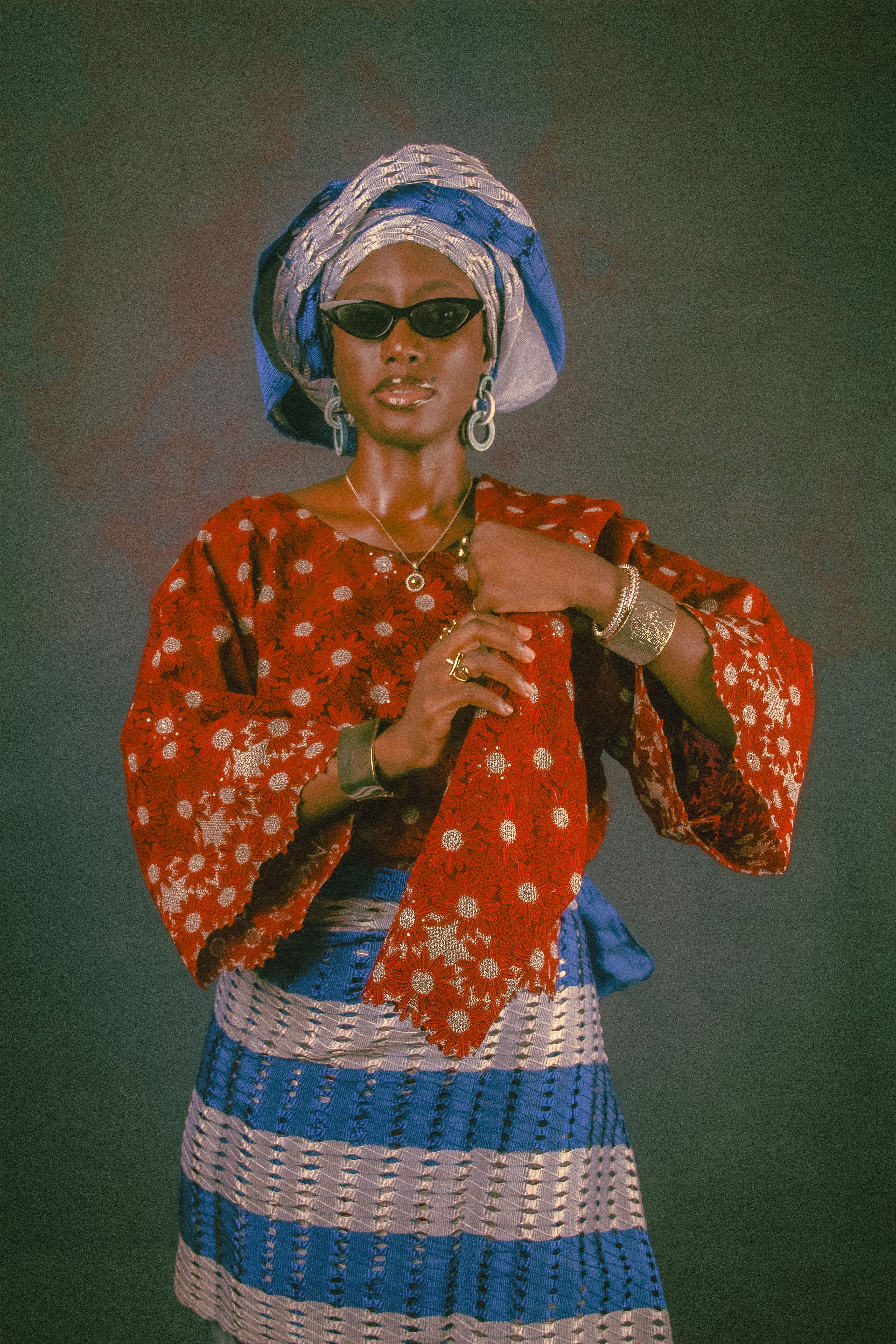Stylish woman poses confidently in vibrant African traditional clothing with accessories.