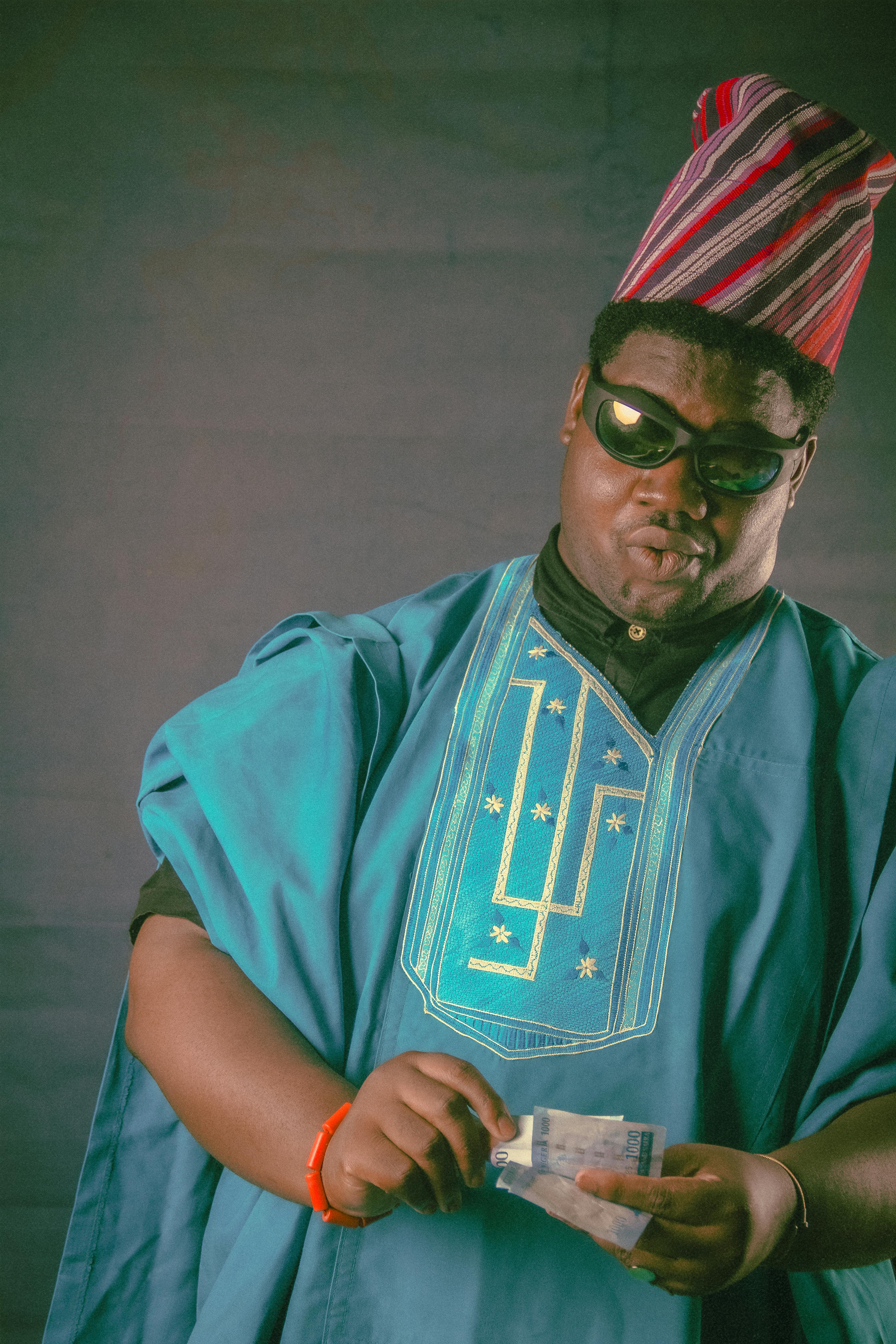Portrait of a man wearing traditional African clothing and sunglasses, presenting style and culture.