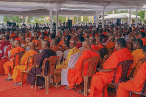 Free A large gathering of Buddhist monks in orange robes attending a temple event in Sri Lanka. Stock Photo